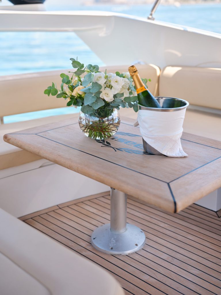 Champagne in ice bucket with floral arrangement on luxury yacht table