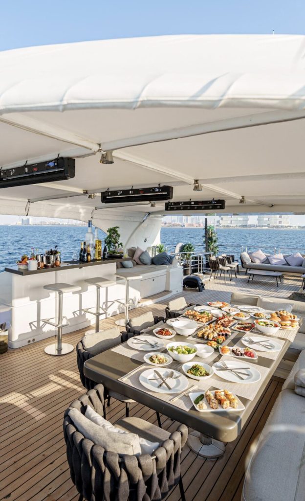 Luxury yacht outdoor dining area with buffet table and bar setup at sea