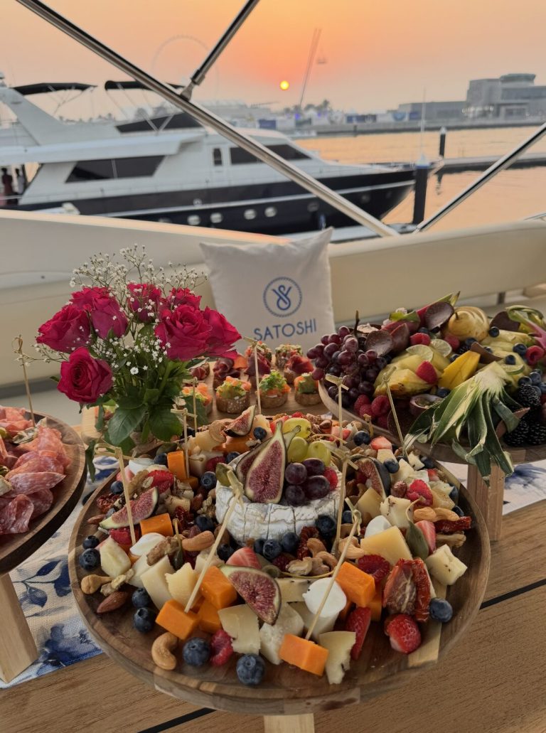 Luxury yacht catering setup with gourmet food platter and flowers onboard Dubai yacht