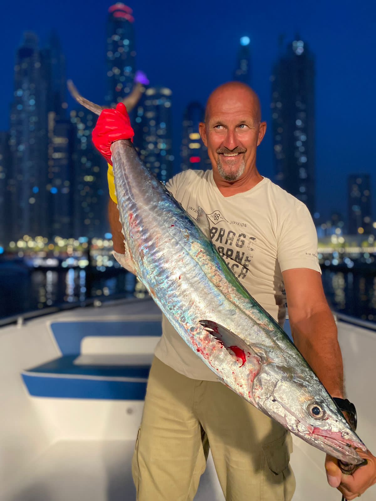 Angler holding large barracuda caught during Dubai deep sea fishing trip