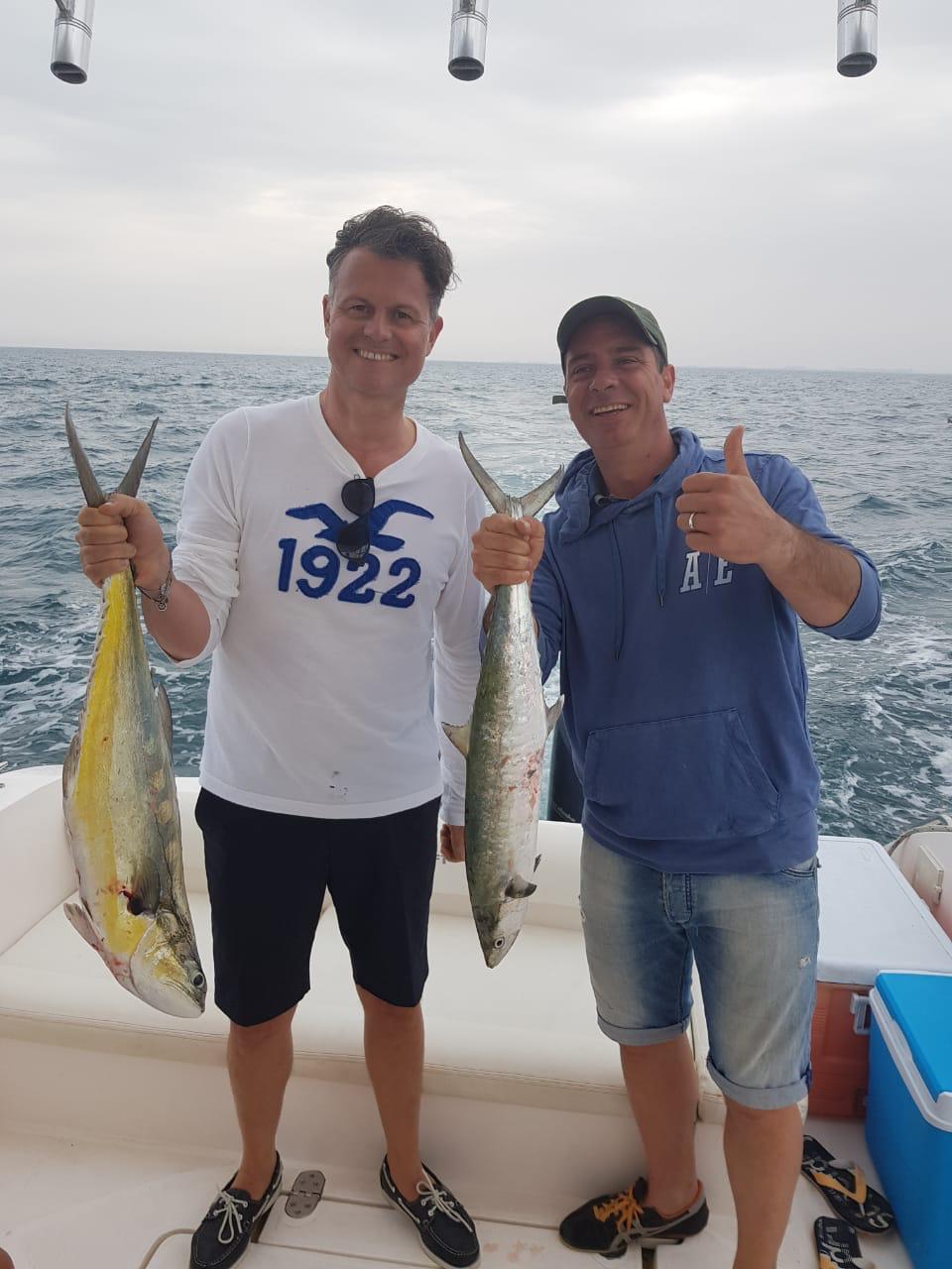Two anglers posing with fresh catch during Dubai fishing charter