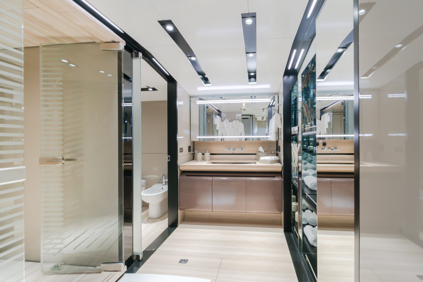 Saffuriya VIP yacht walk-in closet and vanity area with mirrored panels, wood cabinetry and modern lighting