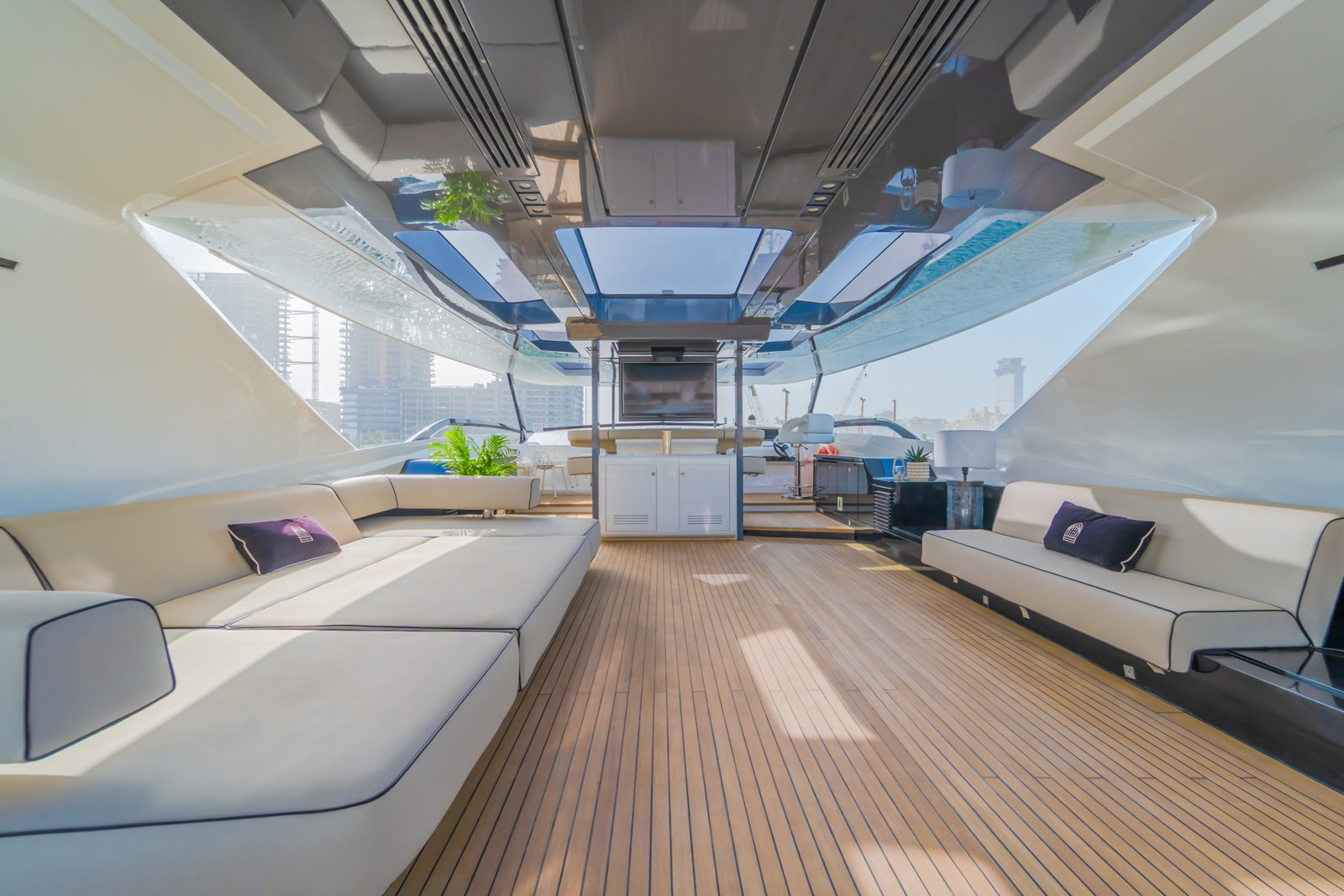 Saffuriya VIP yacht upper deck lounge with cushioned seating, wood flooring and panoramic ocean views