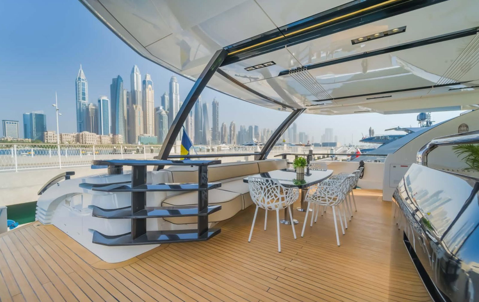 Saffuriya VIP yacht outdoor dining area with marina skyline views, teak flooring and shaded seating