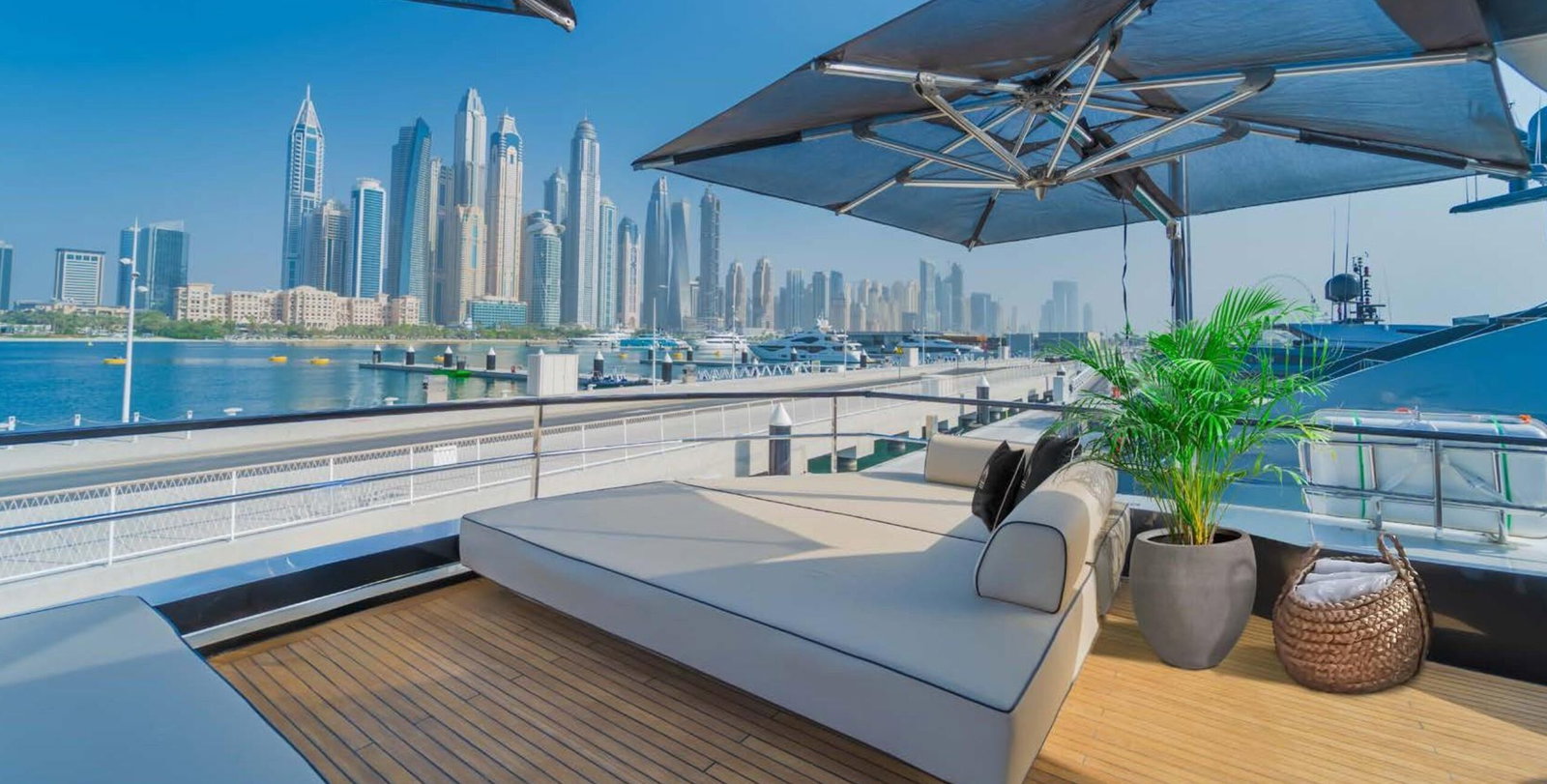 Saffuriya VIP yacht sun lounge deck with cushioned seating, retractable canopy and city skyline backdrop