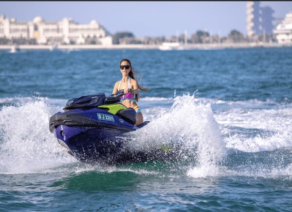 Woman riding jet ski on clear blue water in Dubai
