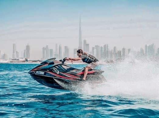 Man riding jet ski with Dubai skyline and Burj Khalifa in background