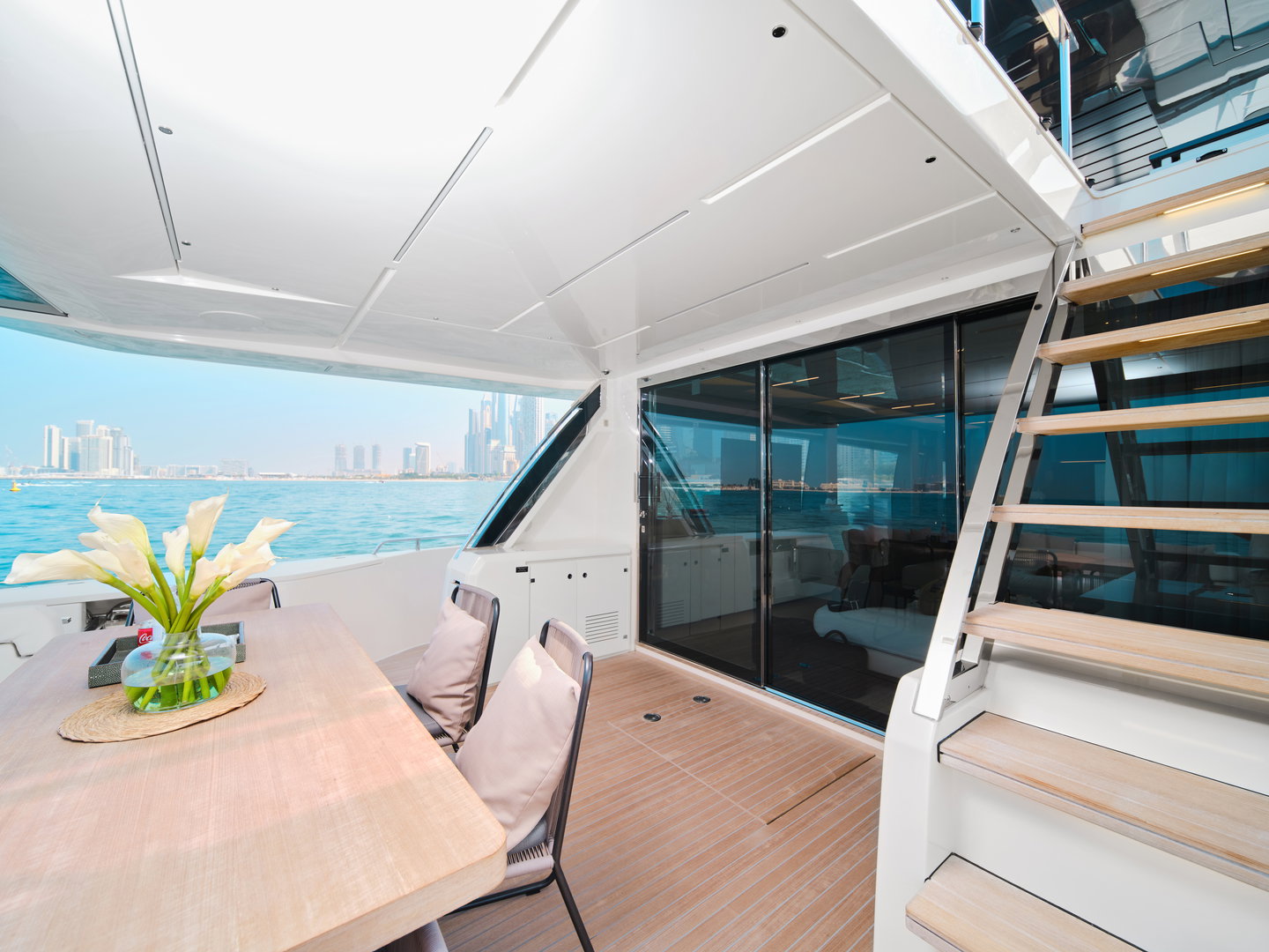 Upper deck lounge area on Ferretti 780 yacht with seating and staircase