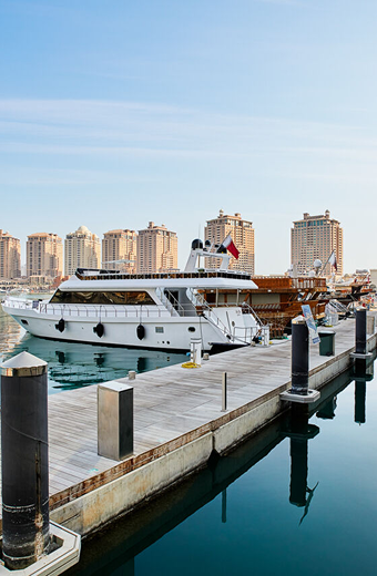 Luxury yacht docked at Dubai Marina with waterfront skyline